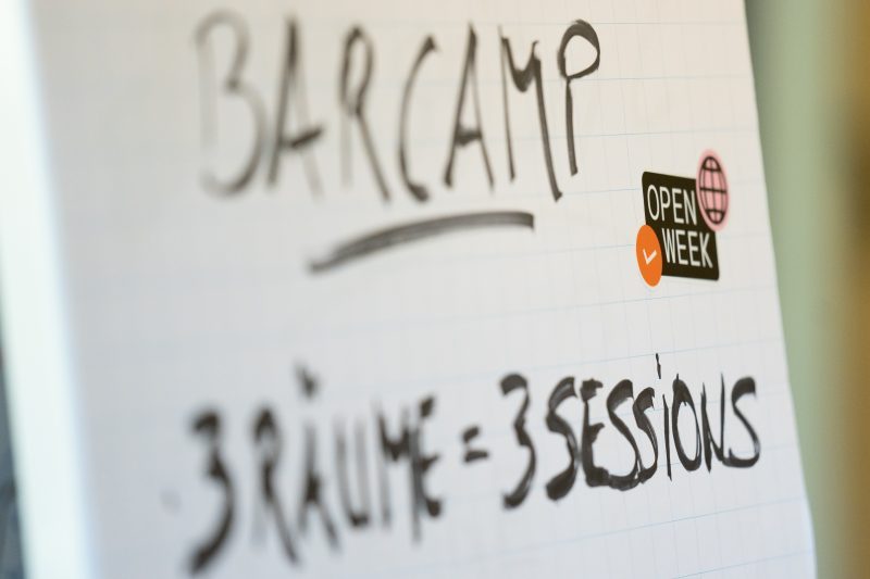 Flipchart mit Aufschrift "Barcamp, 3 Räume = 3 Sessions"