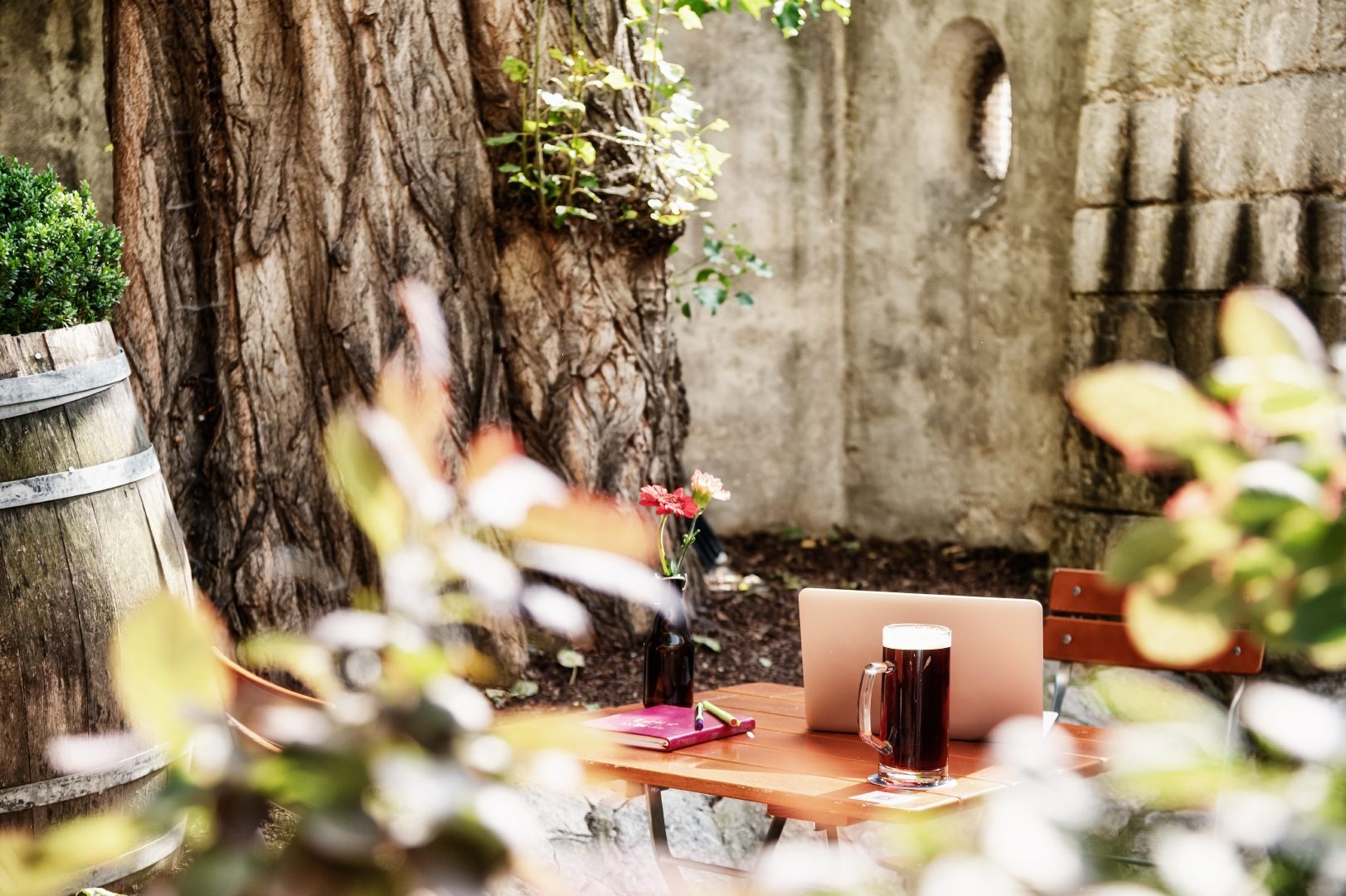 New Work im Biergarten mit Laptop und Bier auf dem Tisch