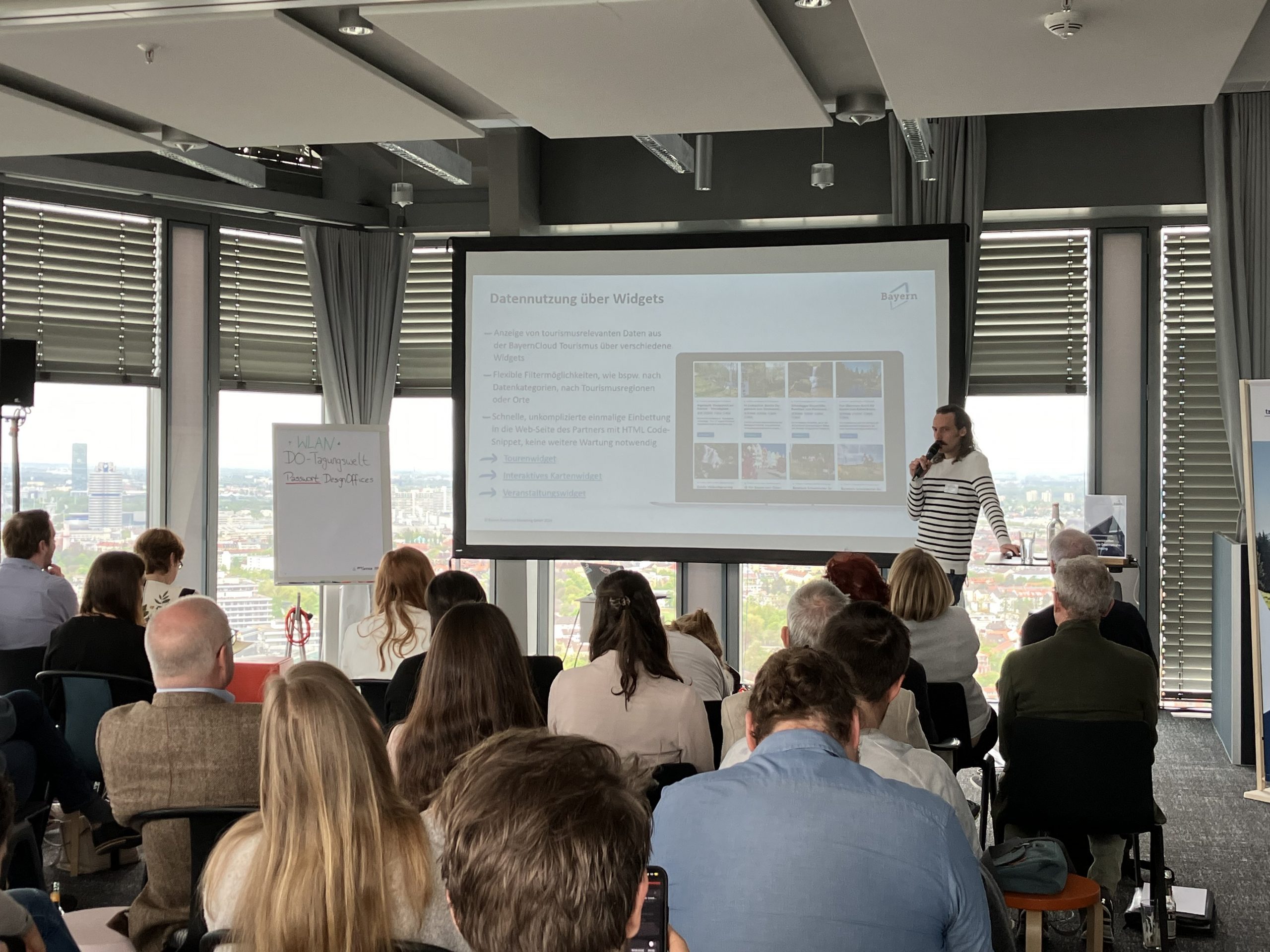 Menschen sitzen vor einer Leinwand beim Netzwerktreffen Digitale Destinationsentwicklung