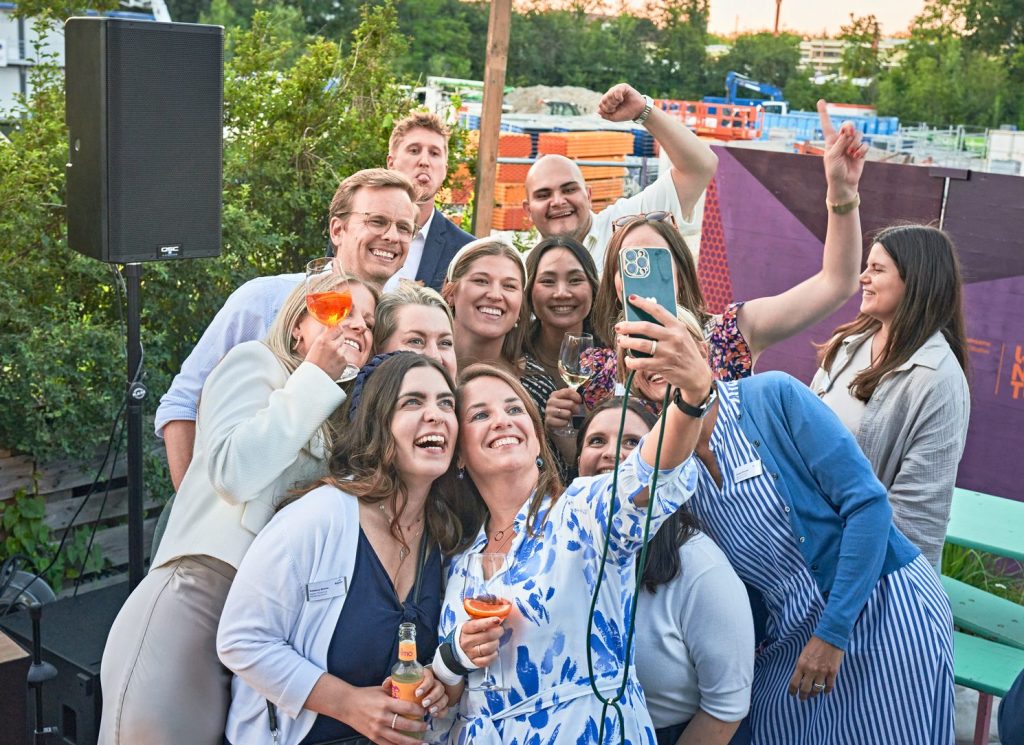 Eine Gruppe von Mitarbeitenden der BayTM steht bei einem Event zusammen und macht ein Selfie.